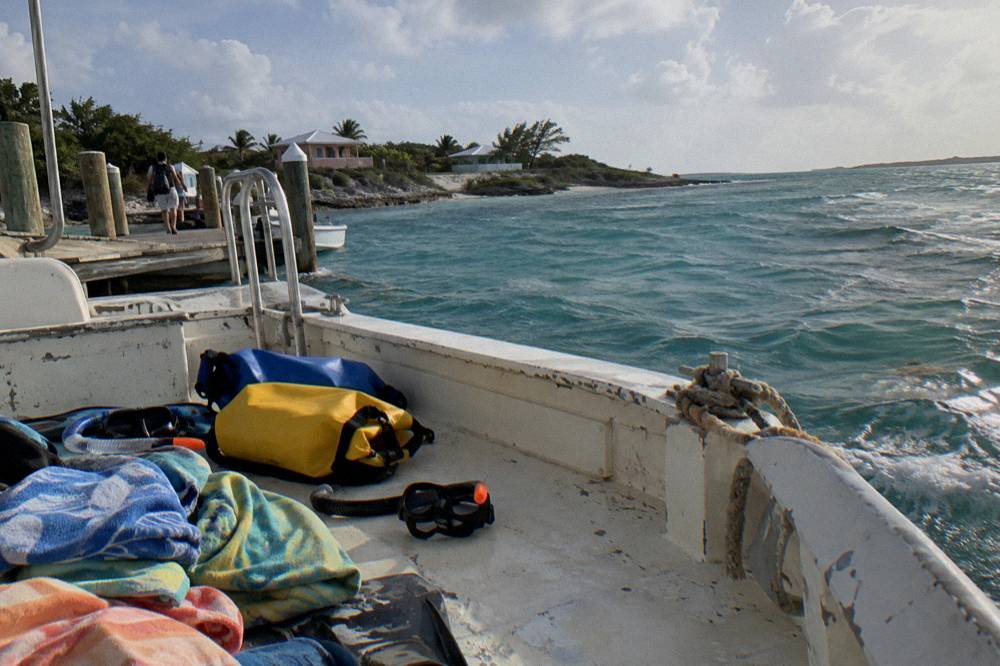 A boat deck with towels, dry bags and snorkel gear laid out for a tour day
