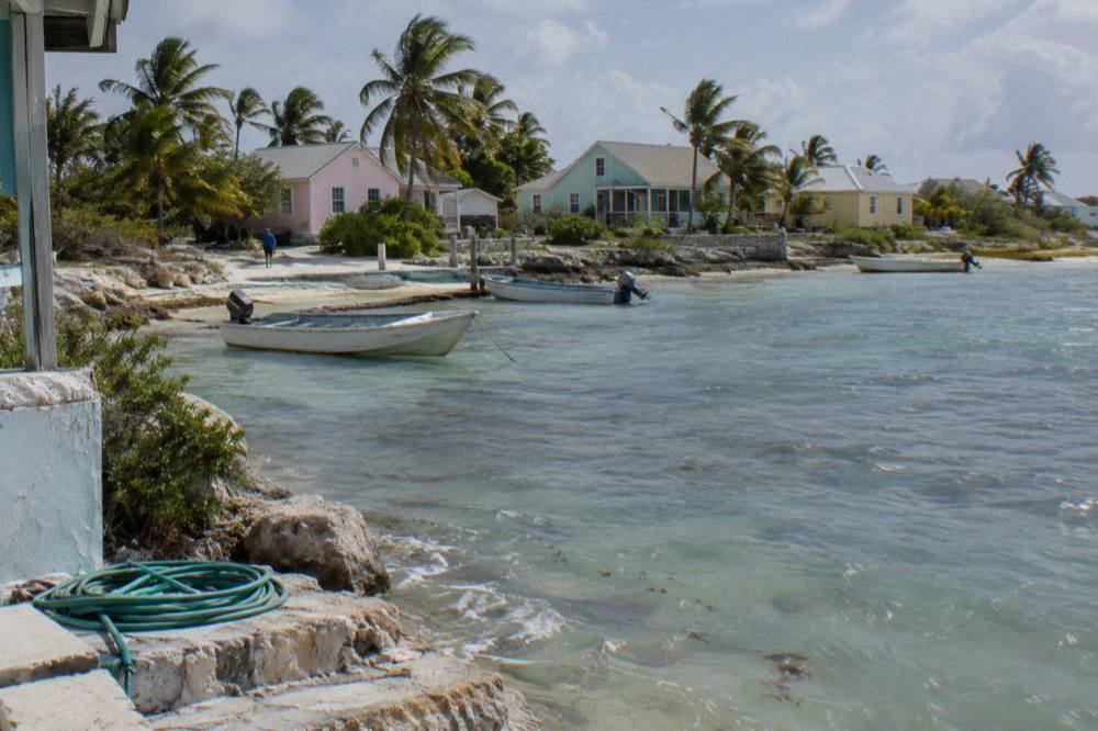 Small resort buildings along a calm bay with moored boats