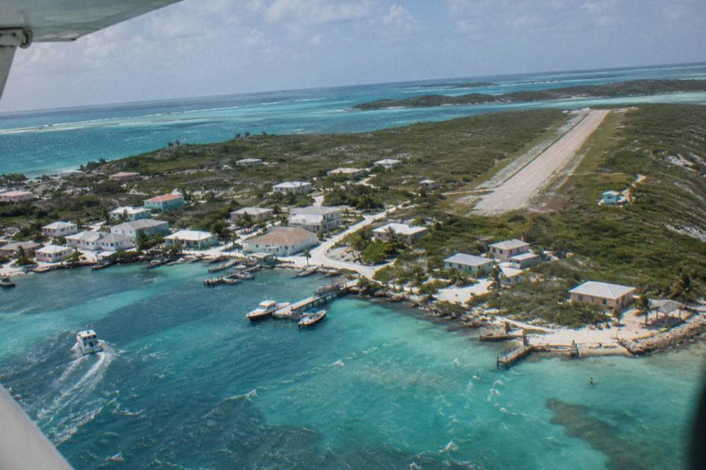 Aerial view of a small island settlement beside turquoise shallows